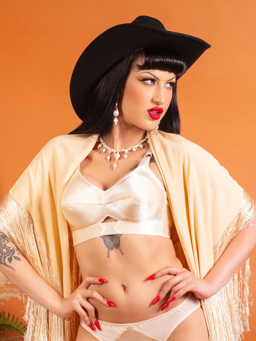 Model wearing Harlow peach satin bullet bra, demonstrating iconic conical shape