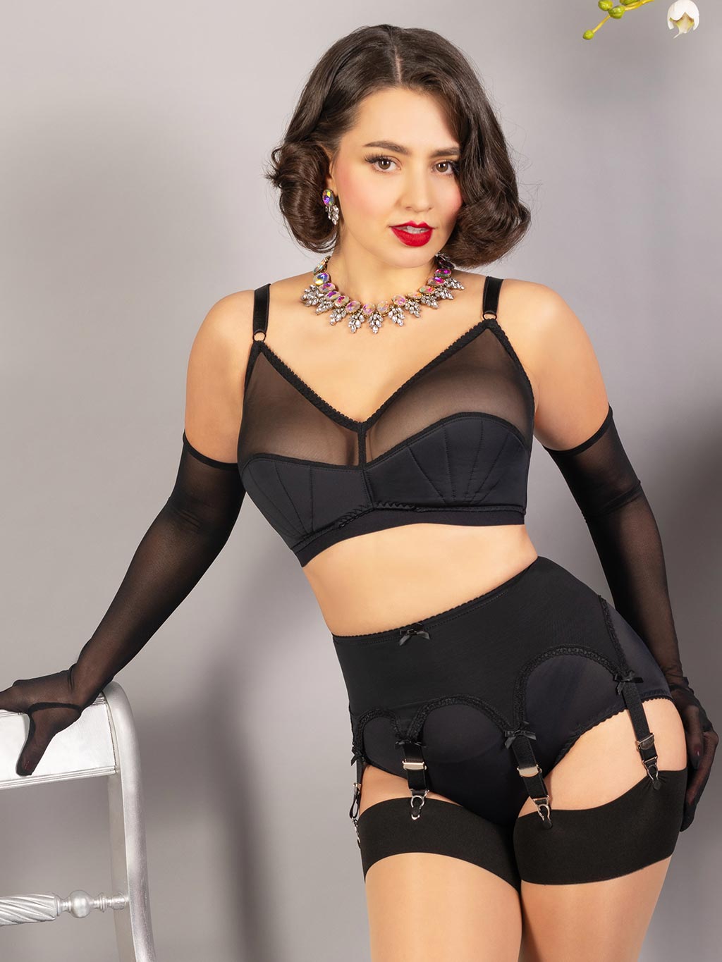 black pull on powermesh suspender belt worn with black soft cup bra and long black gloves