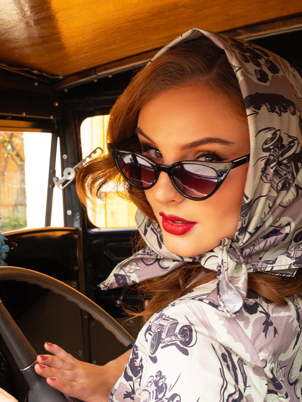 Classic car enthusiast wearing motor racing inspired scarf as headscarf with coordinating outfit