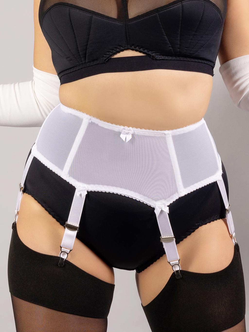 close up of white boned garter belt worn with retro black lingerie