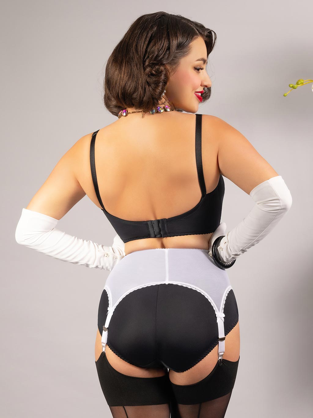 back view of white pull on powermesh suspender belt worn with black lingerie and stockings