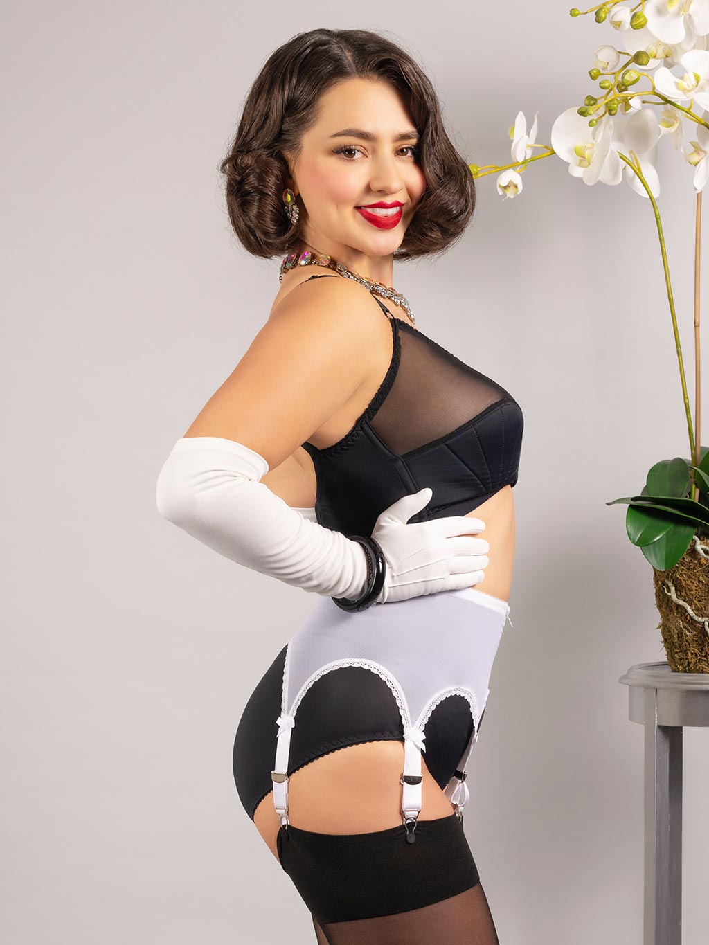 close up side view of white pull on powermesh suspender belt worn with black lingerie and stockings